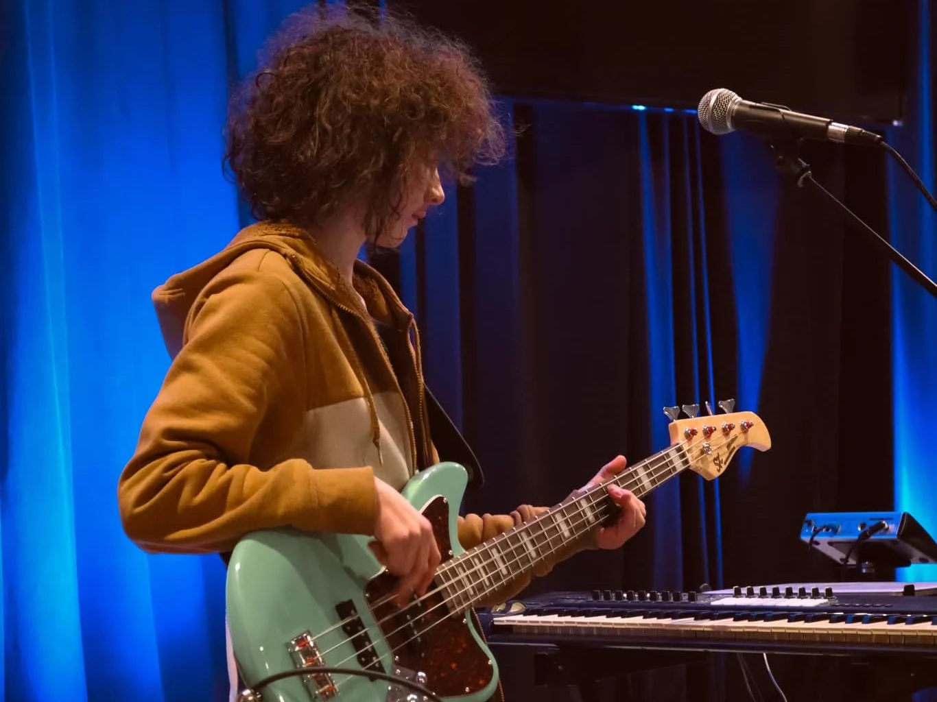 A City Youth student playing bass on stage at Ellijay City Church