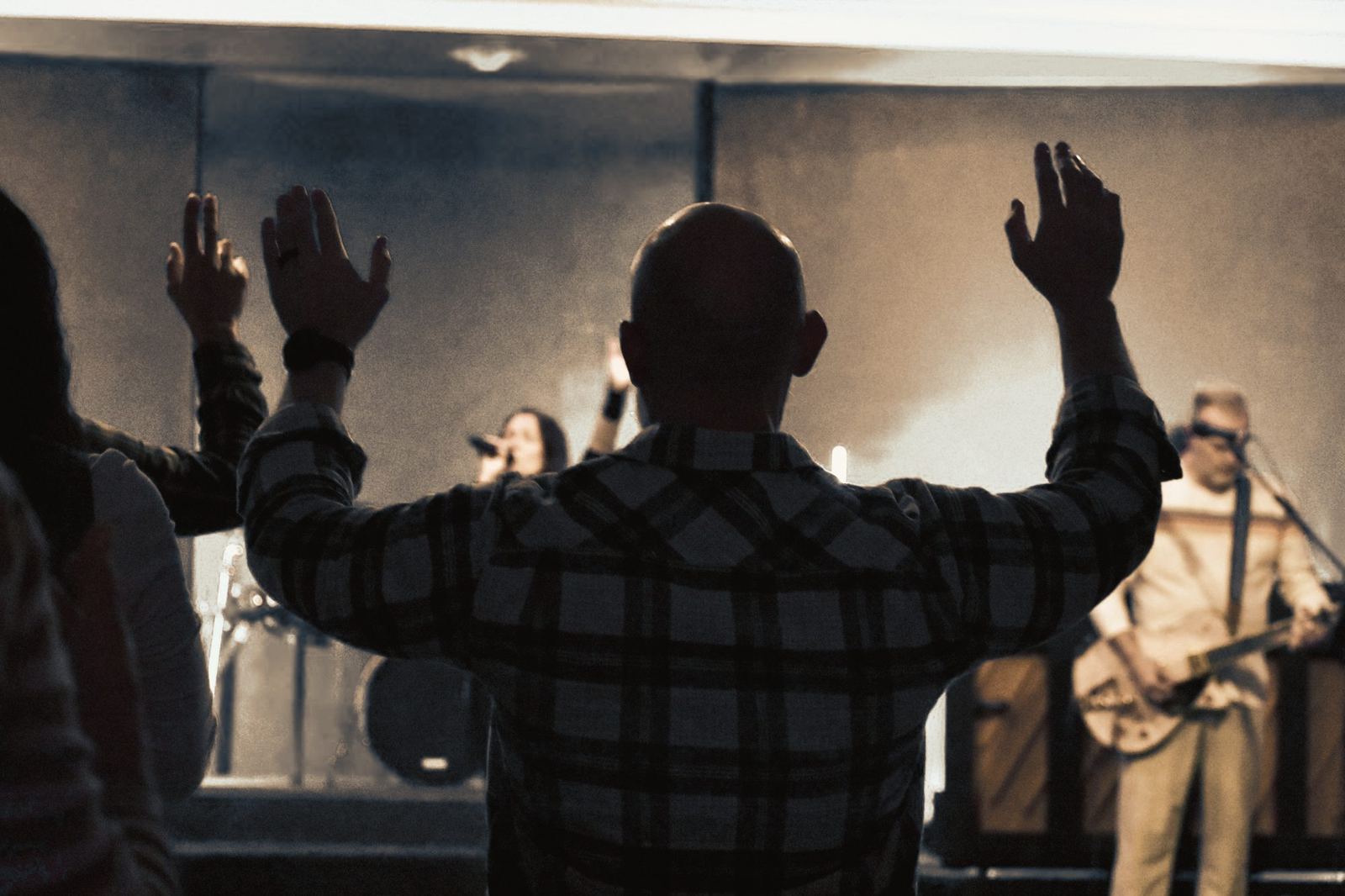 The congregation worshiping with hands raised toward the stage at Ellijay City Church