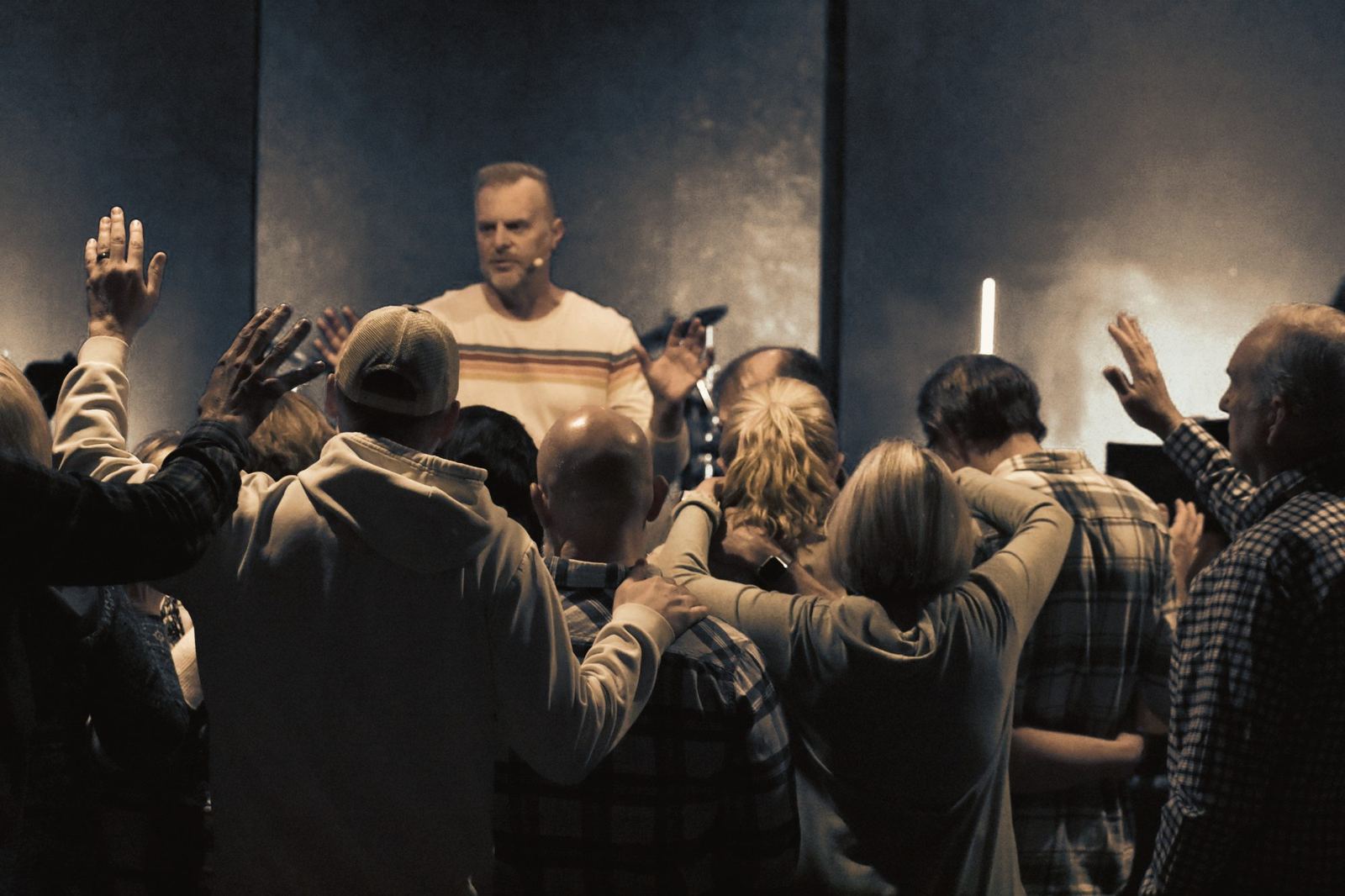 Church members gathered close, praying for one another