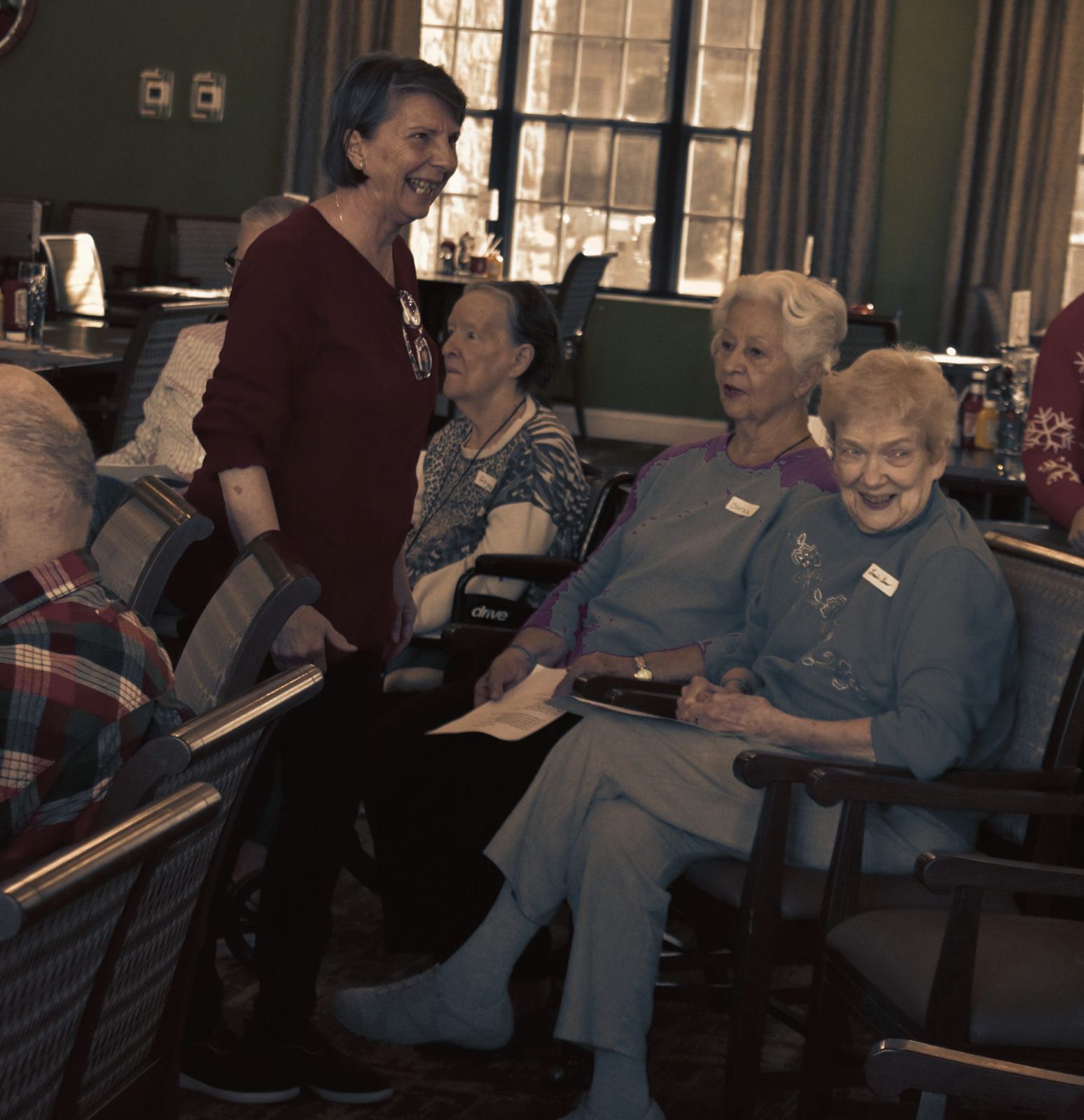 Church members laughing with residents during a Christmas visit to a senior-living community