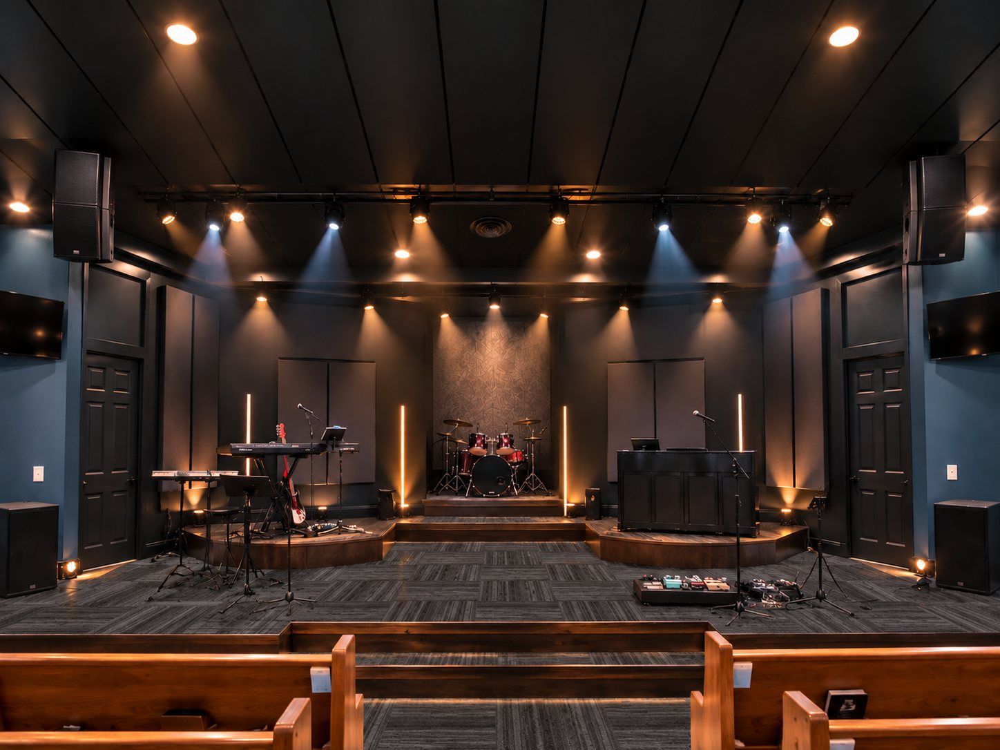 Rendering of the renovated sanctuary: dark timber ceiling, slate walls, warm stage lights and wooden pews