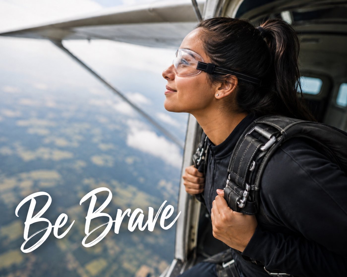 A woman looking out the open door of a small plane over the