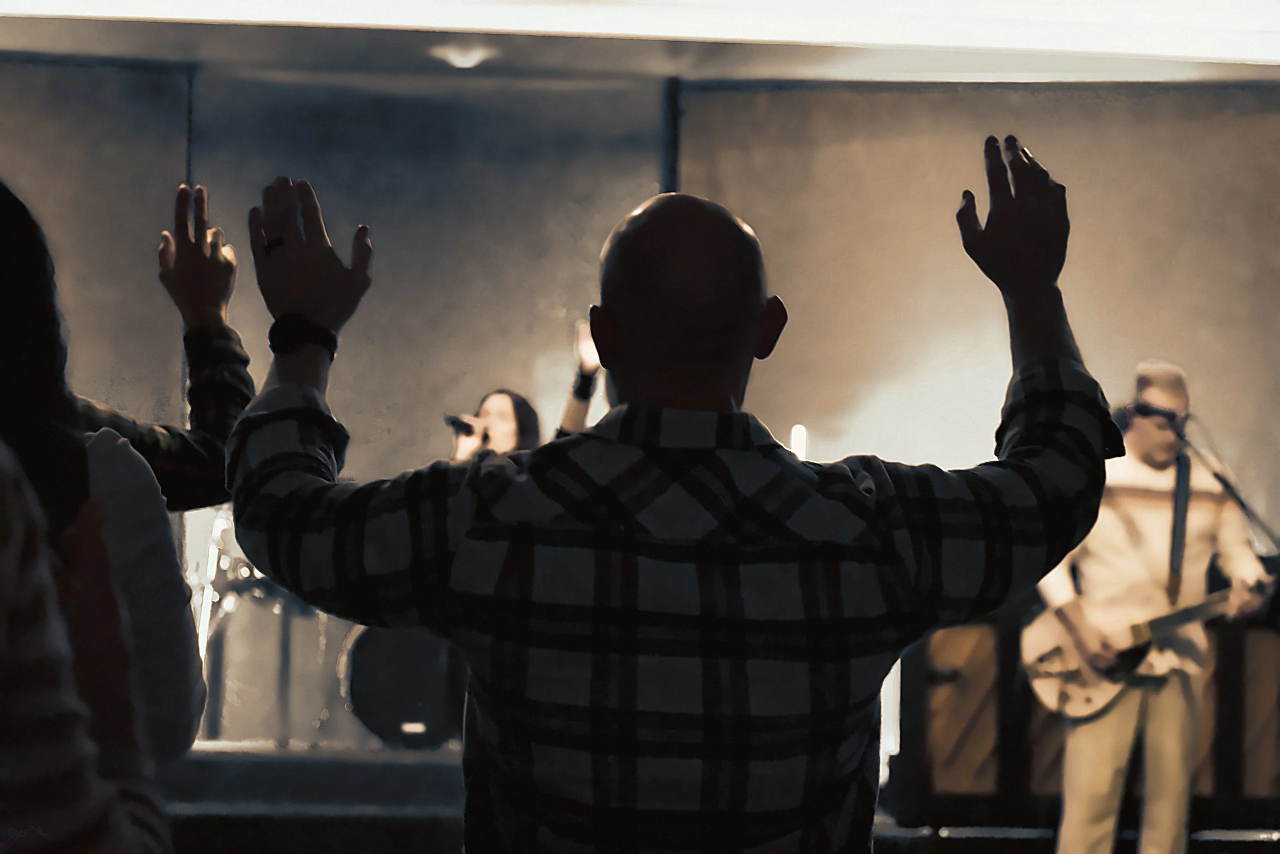 The congregation worshiping with hands raised toward the stage at Ellijay City Church